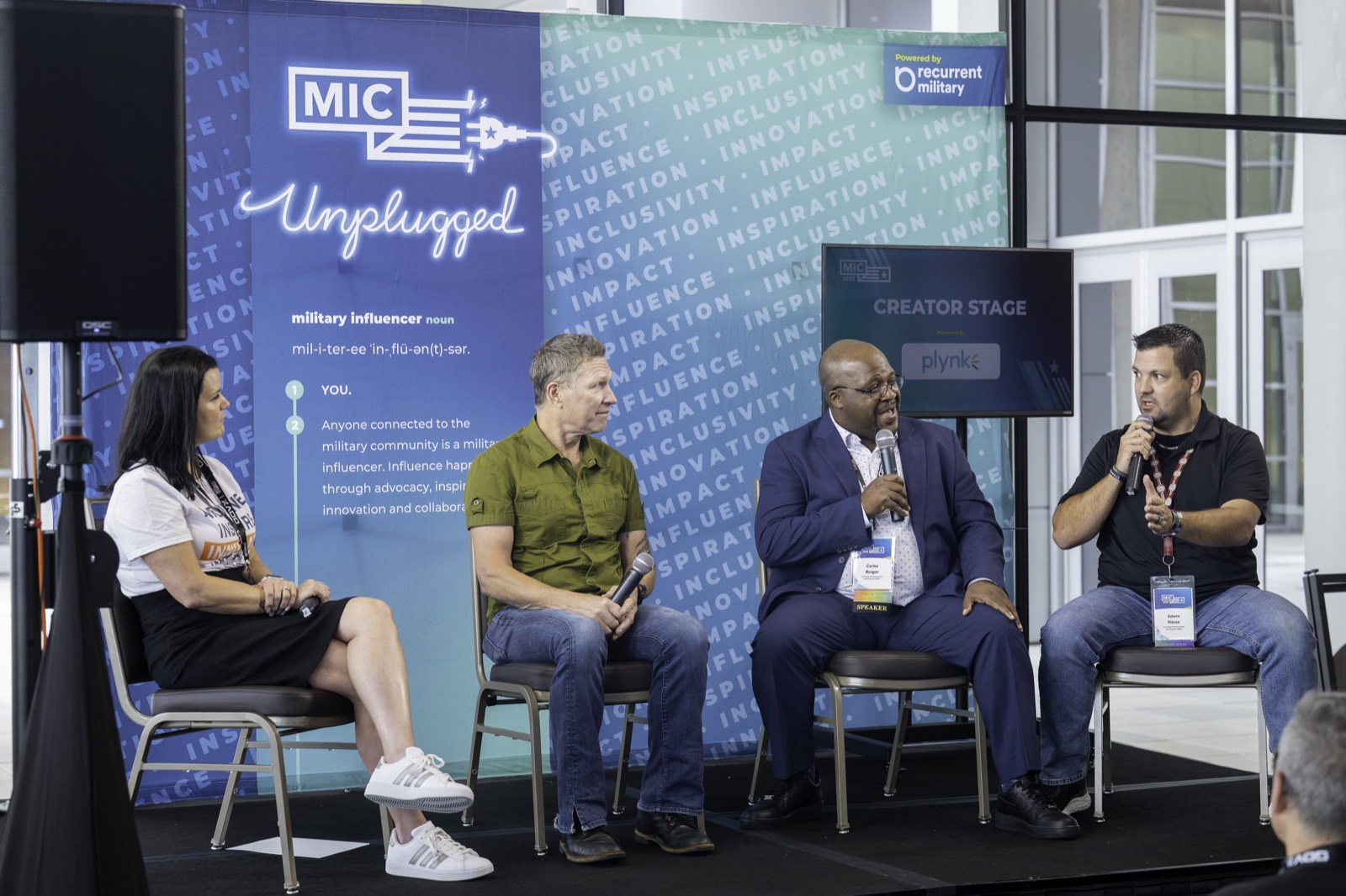 Four speakers seated on the Creator Stage at MIC Unplugged, one holding a microphone mid-conversation